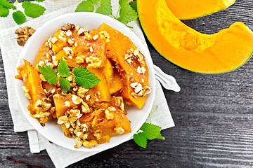 Image showing Pumpkin with nuts and honey on black board top