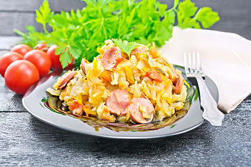 Image showing Cabbage stew with sausages in plate on wooden board