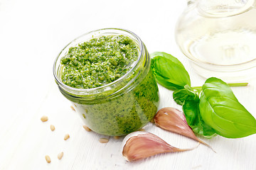 Image showing Pesto in jar on board