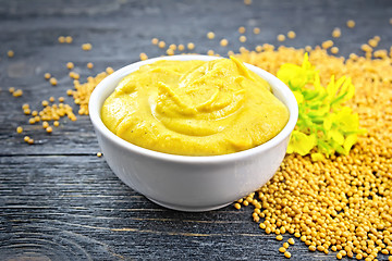 Image showing Sauce mustard in bowl with seeds and flower on board