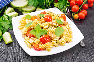 Image showing Fusilli with chicken and tomatoes in plate on board