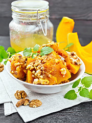 Image showing Pumpkin with nuts and honey on wooden board