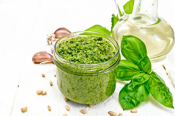 Image showing Pesto in glass jar on light wooden board