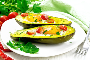 Image showing Scrambled eggs with tomatoes in avocado on board