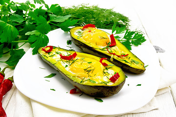 Image showing Scrambled eggs with peppers in avocado on white board