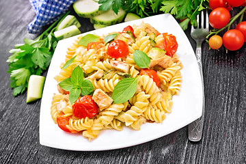 Image showing Fusilli with chicken and tomatoes in plate on dark board