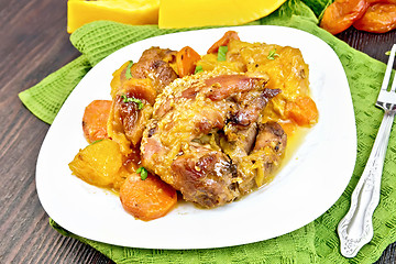 Image showing Chicken roast with pumpkin and dried apricots on dark board