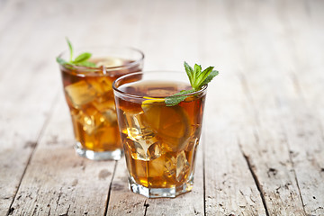 Image showing Two glasses with traditional iced tea with lemon, mint leaves an