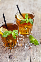 Image showing Traditional iced tea with lemon, mint leaves and ice cubes in tw