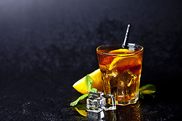 Image showing Traditional iced tea with lemon, mint leaves and ice cubes in gl