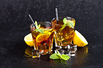 Image showing Two glasses with cold traditional iced tea with lemon, mint leav