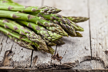 Image showing Bunch of fresh raw garden asparagus closeup on rustic wooden tab