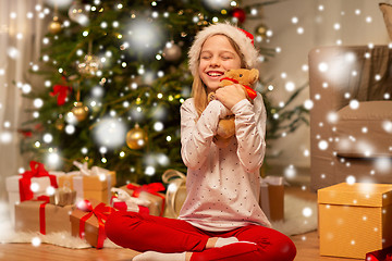 Image showing smiling girl in santa hat with christmas gift