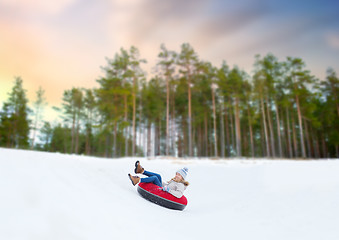 Image showing happy teenage girl sliding down hill on snow tube