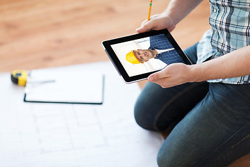 Image showing man having video call with builder on tablet pc