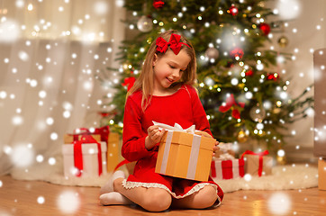 Image showing smiling girl with christmas gift at home