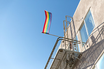 Image showing gay pride rainbow flag waving on building balcony