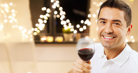 Image showing happy man drinking red wine at home on christmas