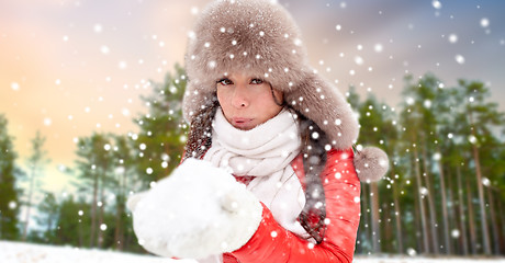 Image showing woman in fur hat with snow over winter forest