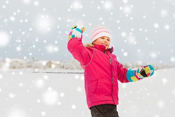 Image showing happy girl playing and throwing snowball in winter