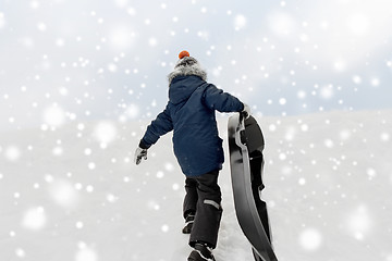 Image showing little boy with sled climbing snow hill in winter