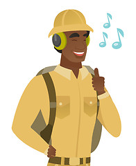 Image showing African traveler listening to music in headphones.