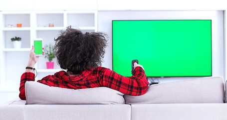 Image showing Young couple on the sofa watching television