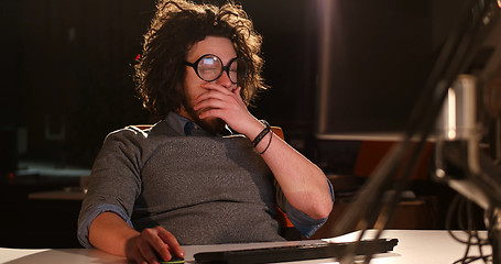 Image showing man working on computer in dark office