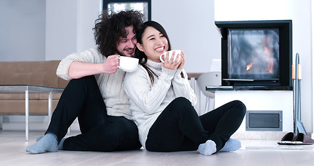 Image showing multiethnic romantic couple  in front of fireplace