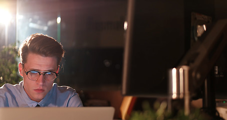 Image showing man working on computer in dark office