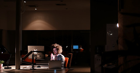 Image showing man working on computer in dark office