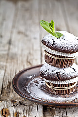 Image showing Fresh dark chocolate muffins with sugar powder and mint leaf on 