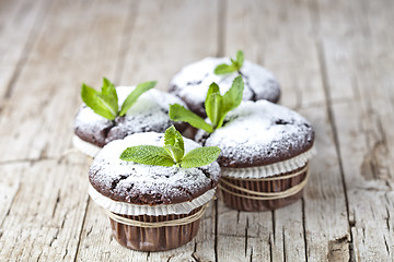 Image showing Fresh chocolate dark muffins with sugar powder and mint leaf on 