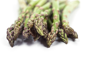 Image showing Bunch of fresh raw garden asparagus closeup on white background.