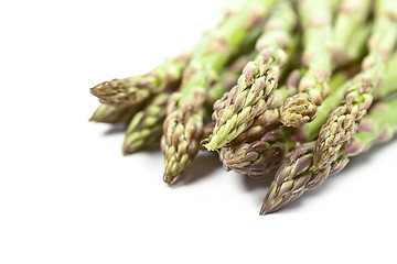 Image showing Bunch of fresh raw garden asparagus closeup on white background.