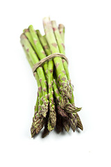 Image showing Bunch of fresh raw garden asparagus closeup on white background.