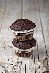 Image showing Two dark chocolate dark muffins on rustic wooden table.