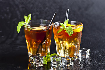 Image showing Two glasses with cold traditional iced tea with lemon, mint leav