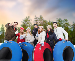 Image showing happy friends with snow tubes outdoors in winter