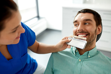 Image showing dentist choosing tooth color for patient at clinic