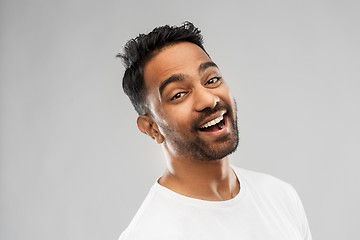 Image showing young laughing indian man over gray background