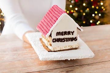 Image showing close up of woman with christmas gingerbread house