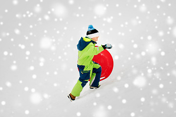 Image showing happy boy with snow saucer sled in winter