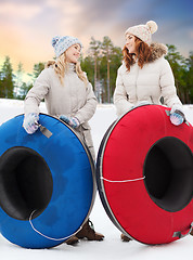 Image showing happy teenage girls with snow tubes in winter