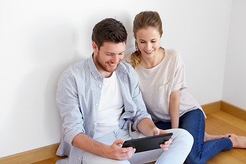 Image showing happy couple with tablet pc computer at new home