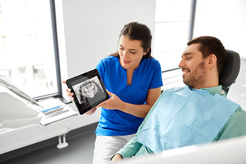 Image showing dentist showing panoramic dental x-ray to patient