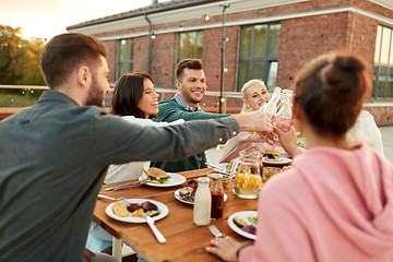 Image showing happy friends toasting drinks at rooftop party