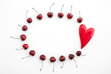 Image showing Frame made of cherries and red wooden heart