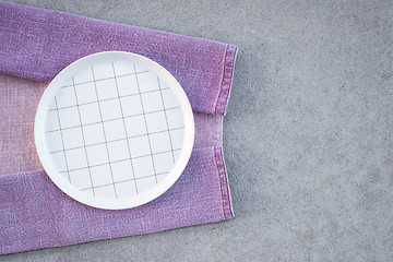 Image showing Checked white plate and lilac tablecloth