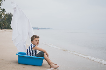 Image showing One happy little boy playing on the beach at the day time.